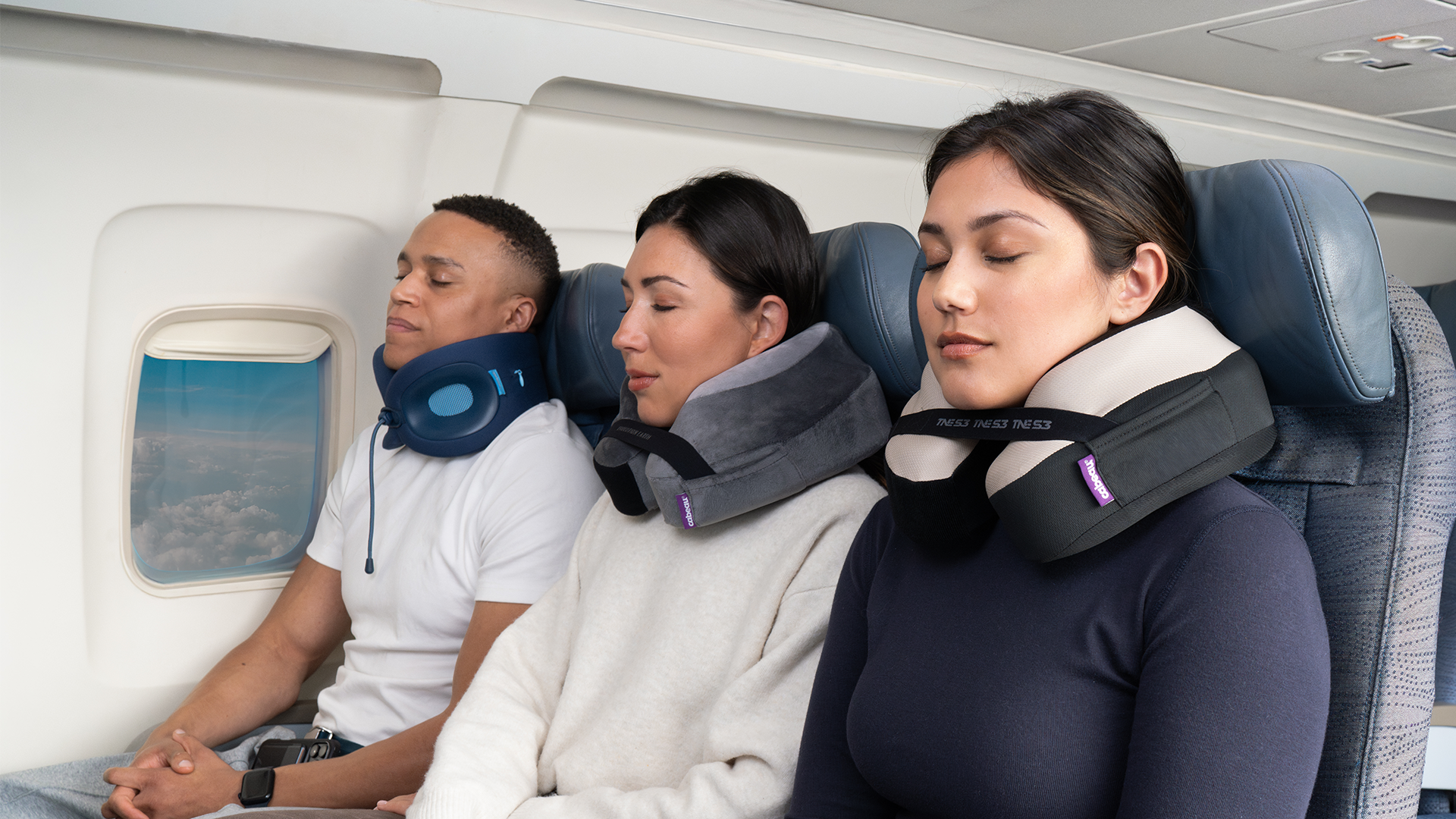 Three people on an airplane with neck pillows, looking relaxed.